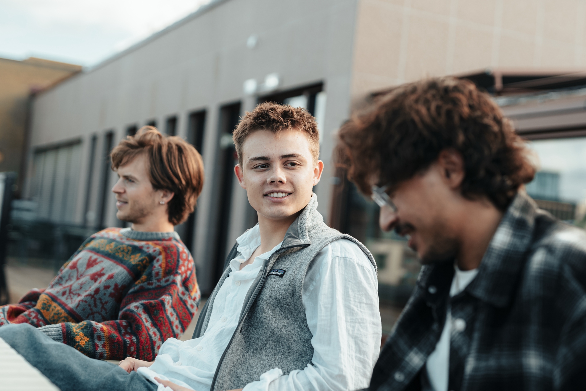 Foto av en gruppe studenter som sitter og ser på en foreleser som peker på opphengte post-it lapper. 