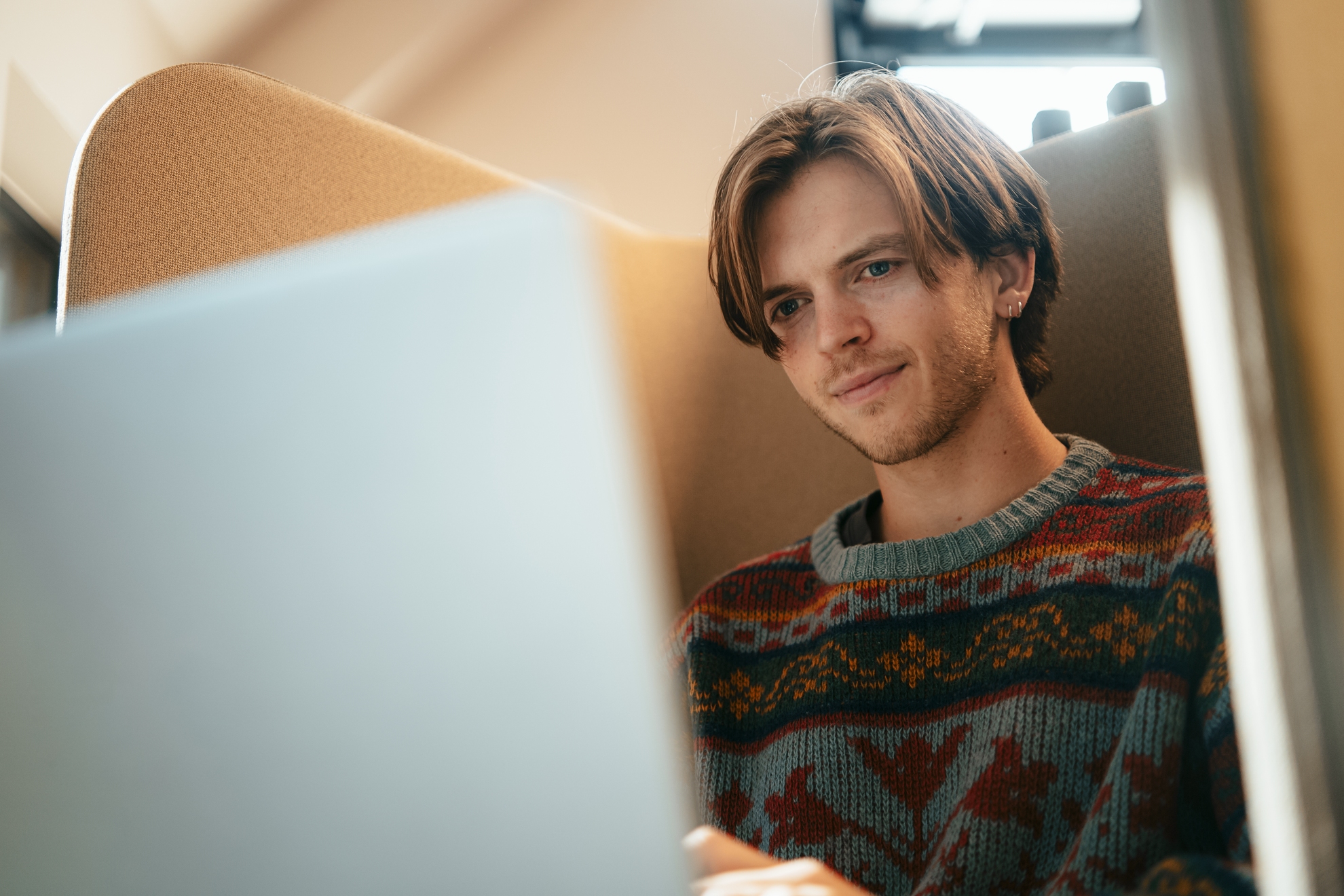 Foto av to mannlige studenter som sitter i et klasserom og ser på en PC.
