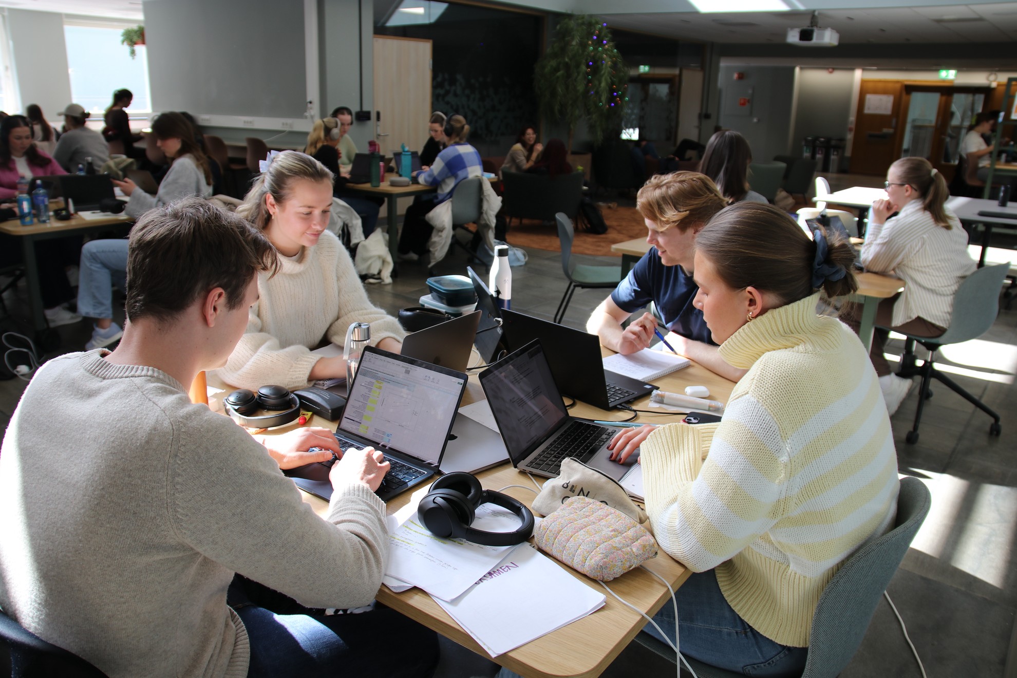 Fire studenter jobber sammen firkanta bord