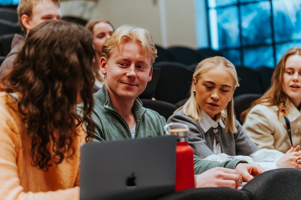Fire studenter sitter og har en samtale. Foto