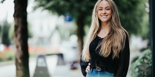 En kvinnelig student ser mot kamera og smiler. Foto