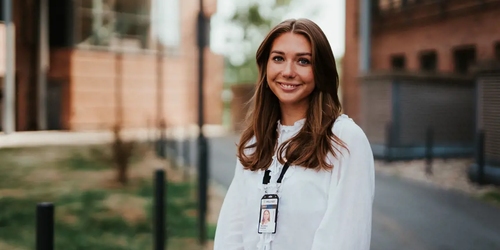 Kristine ser mot kamera og smiler. Foto